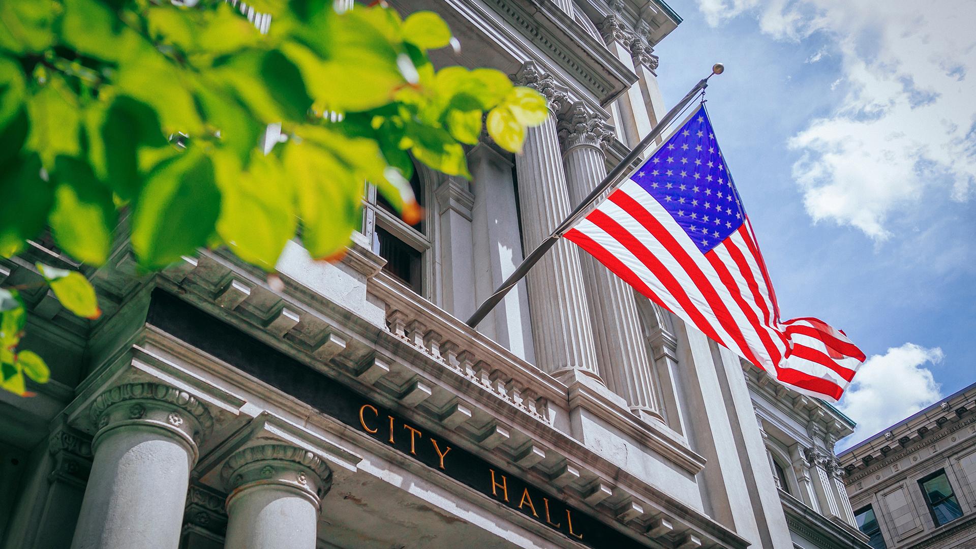 US Flag and the Old City Hall of Boston, USA